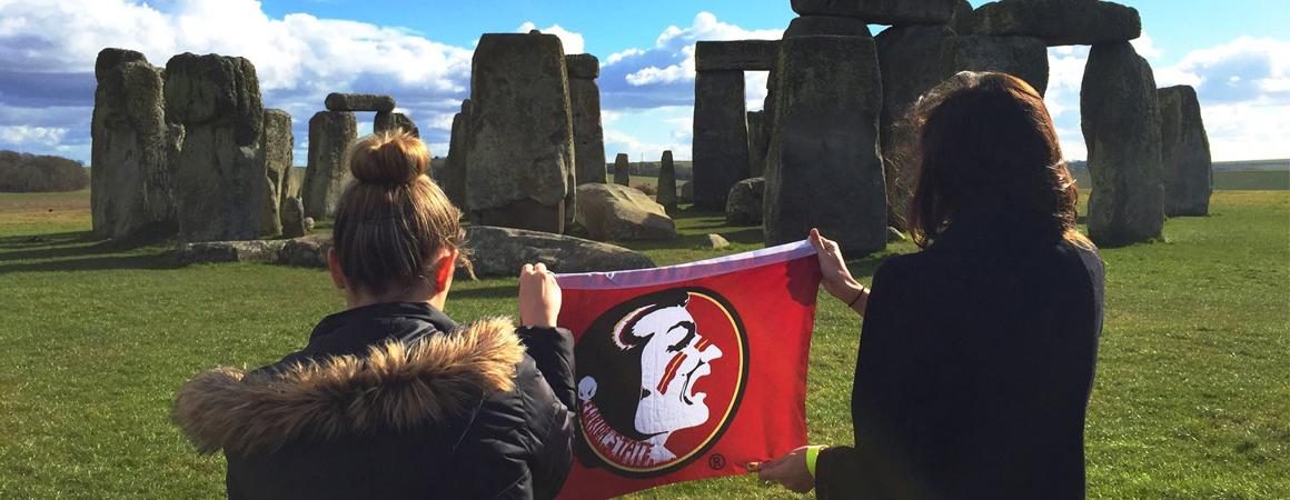 Students holding an FSU flag at Stonehenge